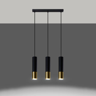 Three black and gold pendant lights turned on, casting warm light onto the grey surface below.