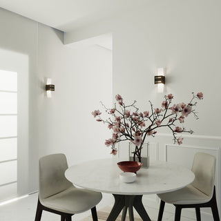 A pair of black wall lights installed on adjacent white walls in a dining area, illuminating a corner.