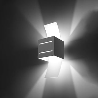 Front view of the cubic wall light demonstrating the wide wash of light above and below the fixture.