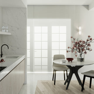 Wall lamp installed next to a large window in a modern kitchen with a marble counter and dining table.