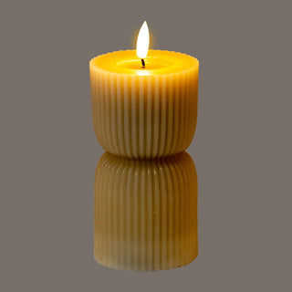 Lit stone effect LED candle reflected on a dark surface.