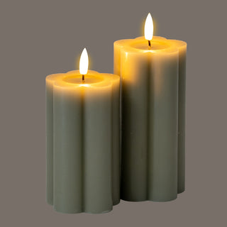 Two fluted grey LED pillar candles of different heights lit up against a dark background.