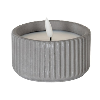 Front view of the small LED candle in a grey ribbed holder with a white faux flame.
