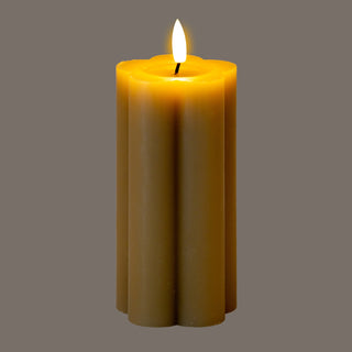 Tall, stone-coloured LED candle with a scalloped edge and a bright, lit faux flame.