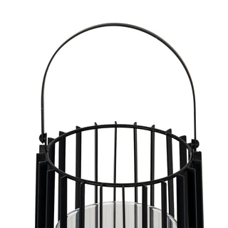 Close-up of the black metal lantern's top rim, vertical bars, and arched wire handle attachment.