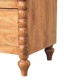 Close-up of the mango wood chest showing the bobble spindle column and the turned front and rear feet.