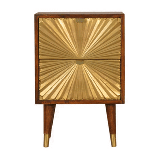 Dark wood bedside cabinet with two drawers featuring textured gold metal fronts radiating from the centre. Tapered legs with brass caps.