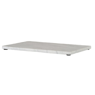 Low angle view of the rectangular marble board showing its thickness, rounded edges, and black protective feet.