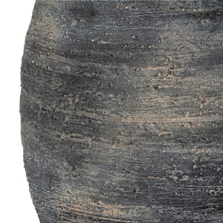 Close detail of the textured, dark grey and brown body of the olpe vase, showing horizontal striations.