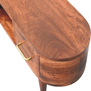 Close-up view of the media unit's curved top surface, showing the dark wood grain and brass drawer handle.