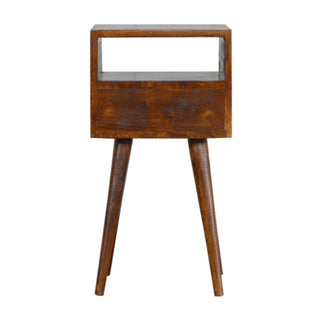 Front view of the mini chestnut bedside table showing the open shelf, drawer, and splayed tapered legs.