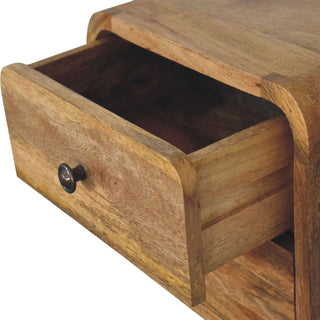 Close detail of the top drawer of the oak-ish bedside cabinet pulled open, showing the internal construction.