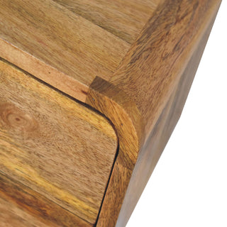 Close-up of the curved drawer edge meeting the rounded side panel of the oak-ish bedside.