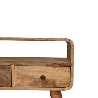Close detail of the curved right side, highlighting the open shelf, drawer, and brass knob.
