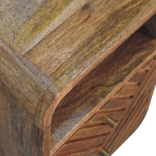 Close detail of the bedside table's curved corner, showing the wood grain and joint construction.