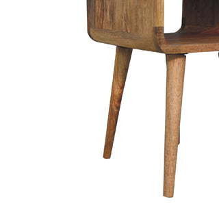 Detail of the two angled, tapered wooden legs and the curved base of the bedside unit.