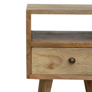 Close-up showing the light mango wood grain, open storage cubby, and drawer.