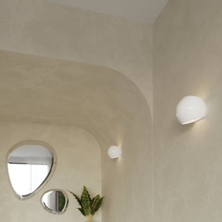 Two white globe lights highlighting textured beige walls and curved architectural features.