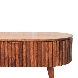 Oval tabletop edge and ribbed wooden body detail, highlighting the integrated drawer pull.