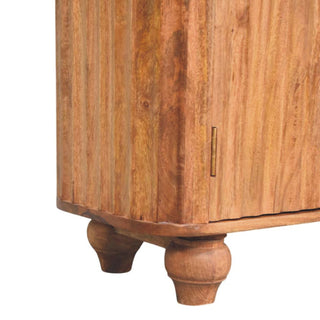 Detail of the turned wooden feet and the reeded texture of the sideboard's curved base panel.