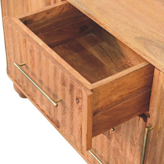 Wooden drawer pulled open, showing the interior construction, reeded front panel, and brass bar handle.