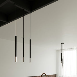 Three pendants hanging from a ceiling beam, with a cluster of four pendants visible in the background near a window.