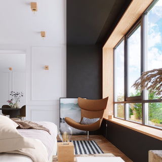 Several natural wood wall lamps mounted on the ceiling and white panelled wall in a contemporary living space.