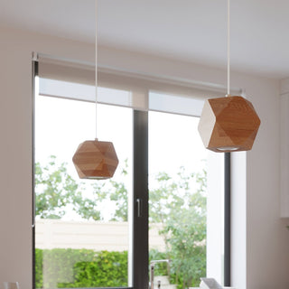 Two geometric wood pendants hanging at different heights against a large window and garden view.