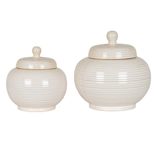 Two pale ceramic lidded jars, large and small, displaying the ridged texture and glossy finish.
