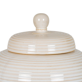 Close-up of the pale ceramic lid showing the spherical finial and horizontal ridging texture.
