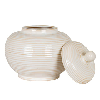 Pale ceramic jar with horizontal ridging, shown with the round lid tilted against the body.