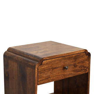 Angled detail shot of the Newton bedside cabinet showing the stepped, curved top profile and dark wood grain.