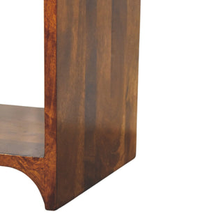 Detail of the chestnut wood side panel and the curved base design of the nightstand.