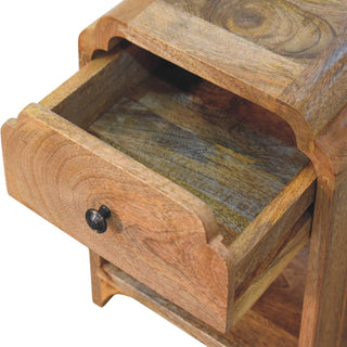 Close-up of the nightstand with the top drawer pulled open, showing the interior wood grain and dark metal knob.