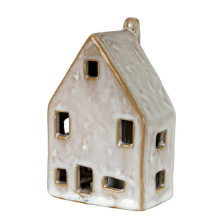 Ceramic house decoration with white uneven glaze and cut-out windows, viewed at an angle.