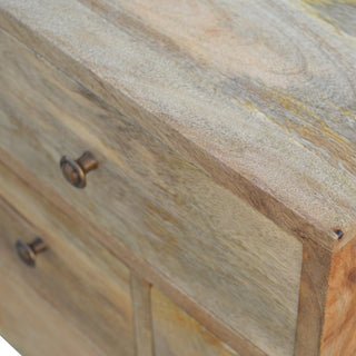 Textured wood grain on the cabinet top and front, contrasting with two antique brass drawer handles.