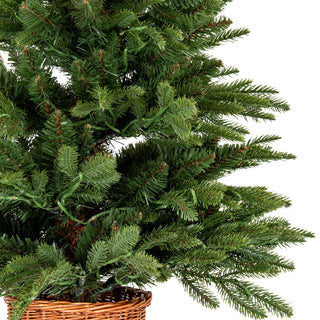 Detail shot of the dense artificial fir branches with pre-lit LEDs, resting in the brown woven rattan pot.