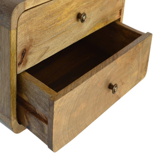 Close-up of the floating bedside unit with the bottom drawer pulled open, showing the internal storage space.