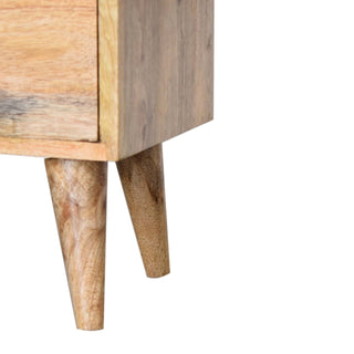 Close-up of the bedside cabinet base and two tapered wooden legs showing the grain.