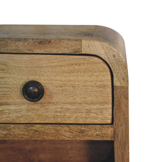 Close detail of the curved top right corner of the bedside unit, highlighting the joint, wood grain, and the drawer knob.