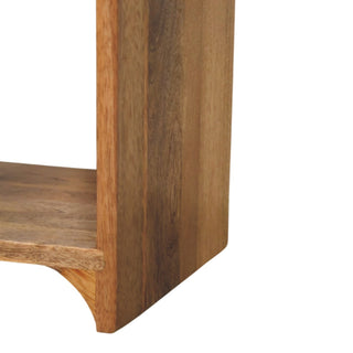 Close-up of the nightstand base showing the curved cut-out detail on the open shelf and the vertical wood grain.