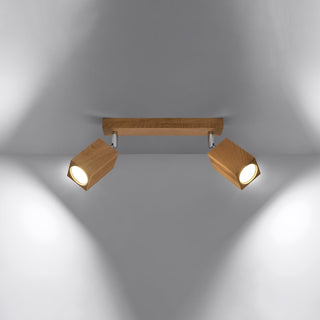 Oak KEKE 2 ceiling light fixture illuminated, casting warm white light beams onto the wall below.