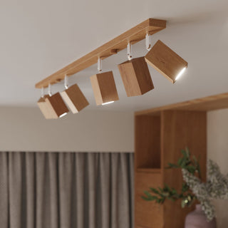 Long oak ceiling bar light featuring five adjustable cuboid spotlights illuminated in a modern room setting.