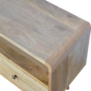 Close-up detail of the light wood grain on the top surface and the smooth, rounded corner of the media unit.