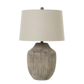 Plain front-on product shot of the table lamp with a ribbed ochre base and a tapered linen shade.