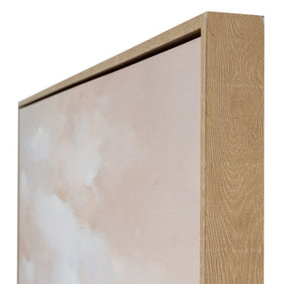 Side profile of the framed canvas, showing the depth and the textured pale wood frame around the pink and white artwork.