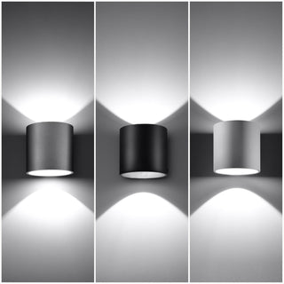 Three cylindrical wall lights (white, black, grey) mounted side by side, demonstrating the directional light.