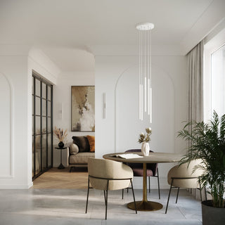 Multi-pendant white cylindrical lights suspended over a round dining table in a bright, modern interior.