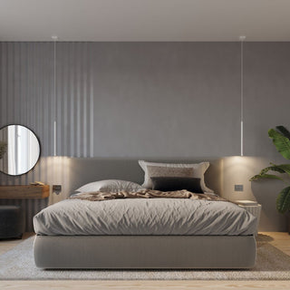 Styled bedroom scene showing two single pendant drops used as symmetrical bedside lighting over a grey bed.