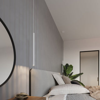 Modern bedroom with two white cylindrical pendant drops hanging at varying depths above a grey upholstered bed.